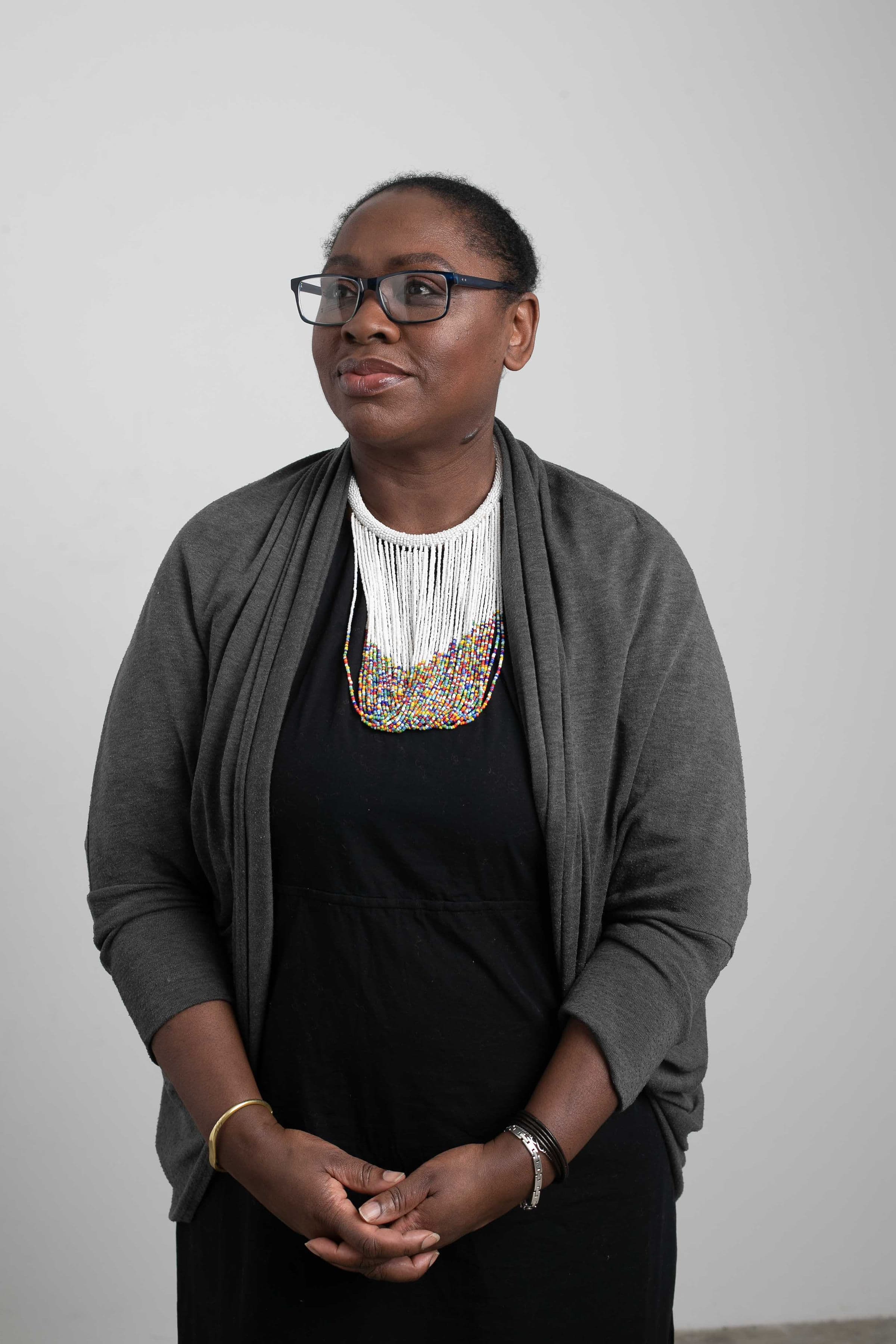 Dawn Dublin seated portrait in a grey cardigan and beaded necklace - ACHFN, African & Caribbean Heritage Food Network